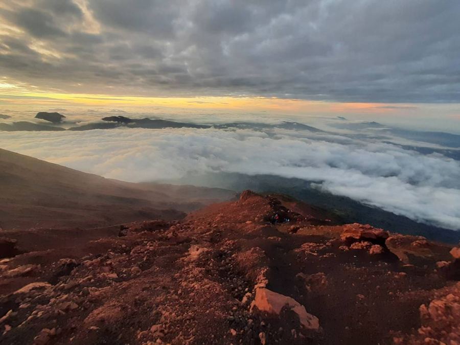 Batuan puncak Gunung Kerinci di atas lautan awan saat matahari terbit