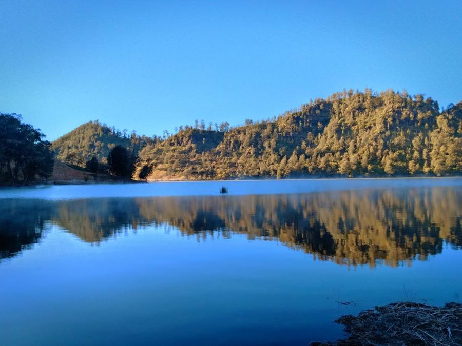 Danau Ranu Kumbolo memantulkan bukit di pagi hari